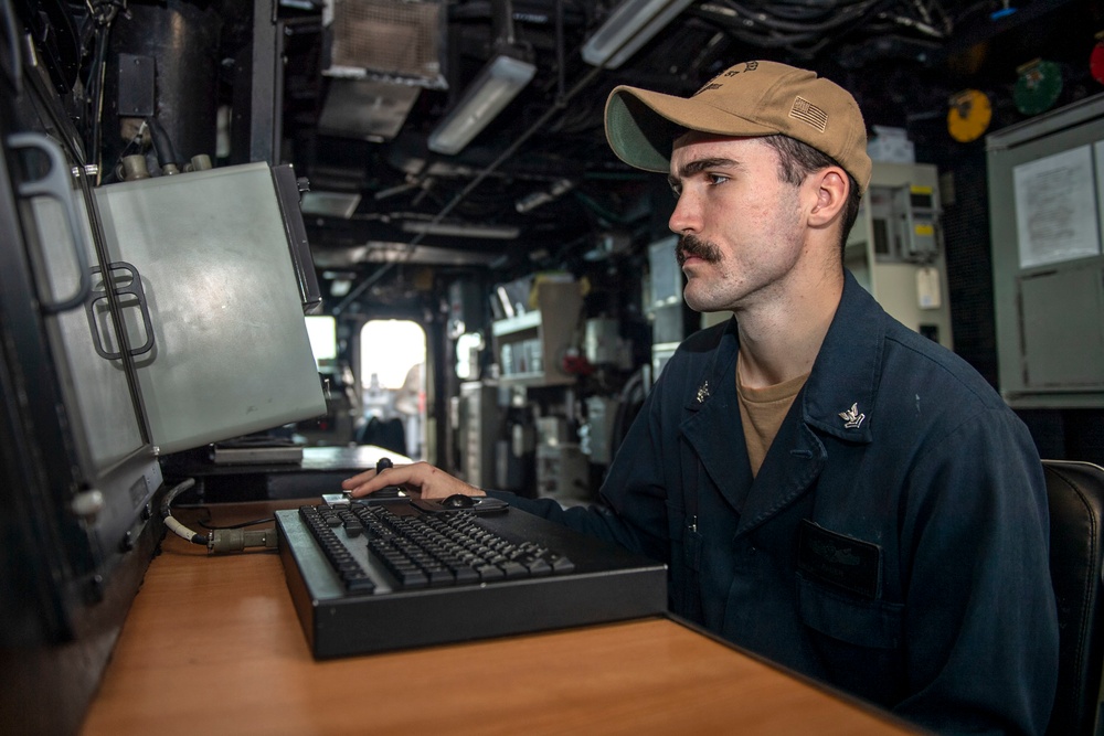 Boatswain’s Mate 2nd Class Justin Bauer, from Fredrick, Colo., searches for surface contacts