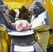 Sailors remove simulated de-contaminated patient from decontamination tent