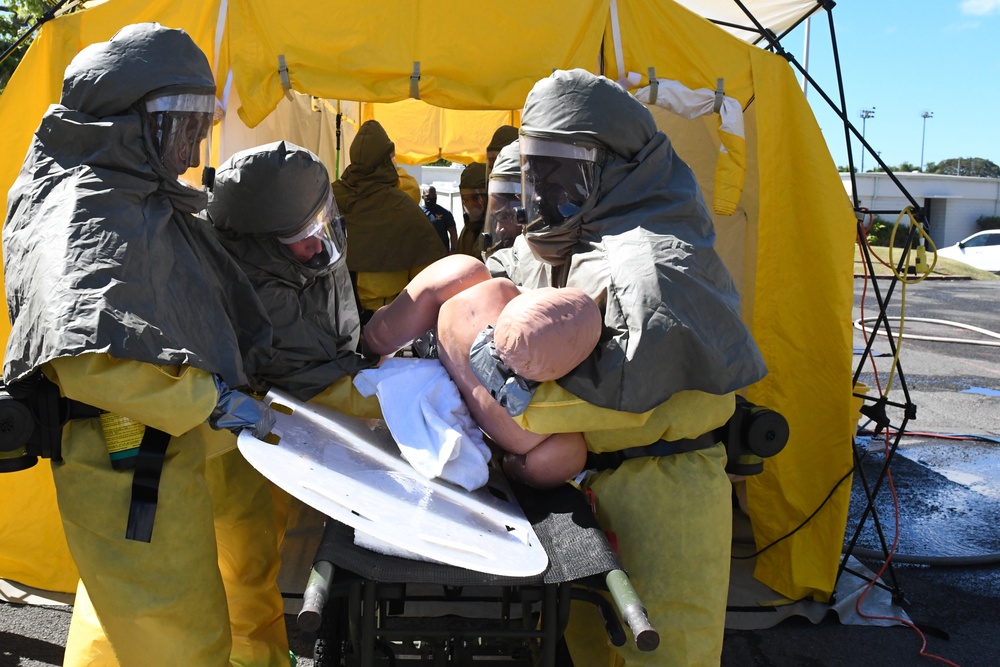 Sailors remove simulated de-contaminated patient from decontamination tent