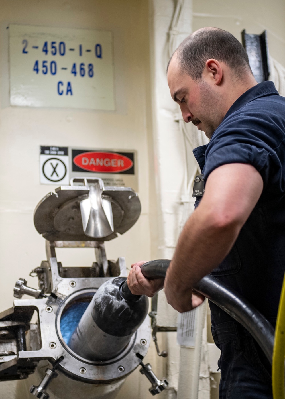 Sonar Technician (Surface) 1st Class Simon Lader (center), from Pensacola, Fla., launches the AN/SLQ-25 Nixie