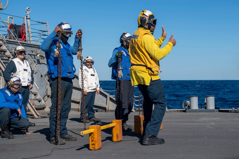 Sailors aboard Arleigh Burke-class guided-missile destroyer USS Mitscher (DDG 57) verify chocks and chains are removed from a MH-60R Sea Hawk helicopter