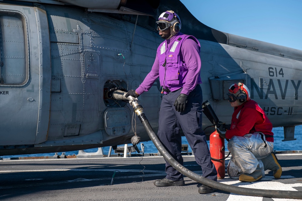 Gas Turbine Systems Technician 3rd Class Demario Spencer (left), from Monroe, La., fuels an MH-60S Sea Hawk helicopter