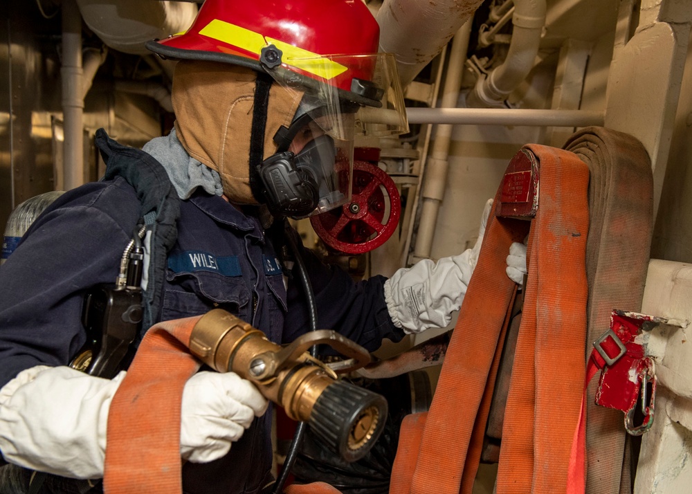 Gas Turbine Systems Technician (Electrical) 3rd Class Zachary Wiley, from Lufkin, Texas, prepares a hose during a firefighting drill