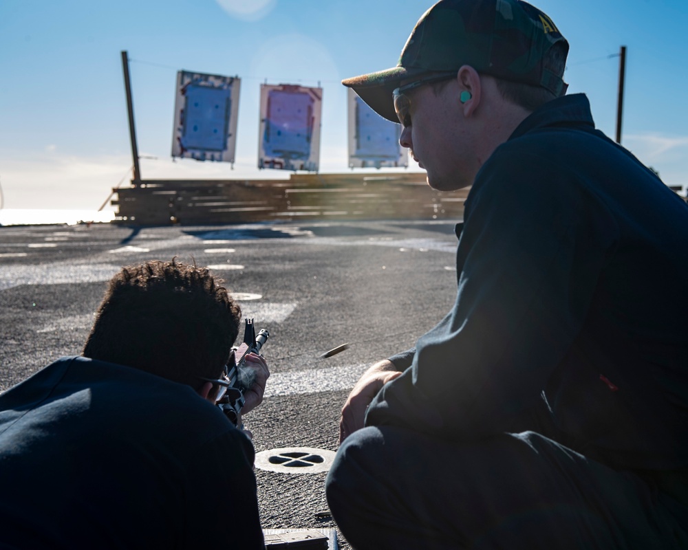 Sonar Technician (Surface) Seaman Jerome Bryant (left), from Milwaukee, Wis., fires an M4 rifle during a rifle qualification course as Gunner’s Mate 3rd Class Sebastian Demarais (right), from Portsmouth, Va., stands as a line coach