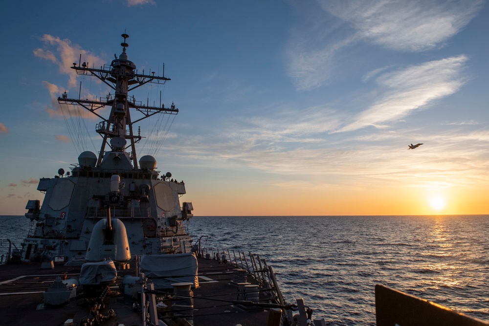 An F/A-18E Super Hornet assigned to the “Blue Blasters” Strike Fighter Squadron 34 conducts a flyby of Arleigh Burke-class guided-missile destroyer USS Mitscher (DDG 57)