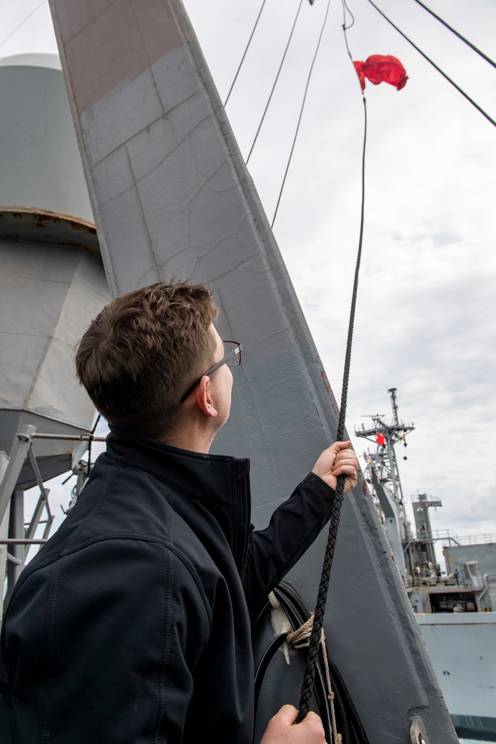 Quartermaster 1st Class John Wagner, from Denver, Colo., hoists the bravo flag during a replenishment-at-sea