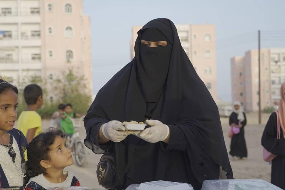 Noor Ahmad Al Baiti serves customers delicacies from her home-based cooking and baking business, Queen Cake, in Mukalla, Yemen on February 22, 2022.