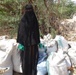 Etimad Saied Mohamed Saied stands among bags of fermented compost, which she sells to local farmers to support her family of six, in the Al Howtta District of Lahj Governorate, Yemen, in February 2022.