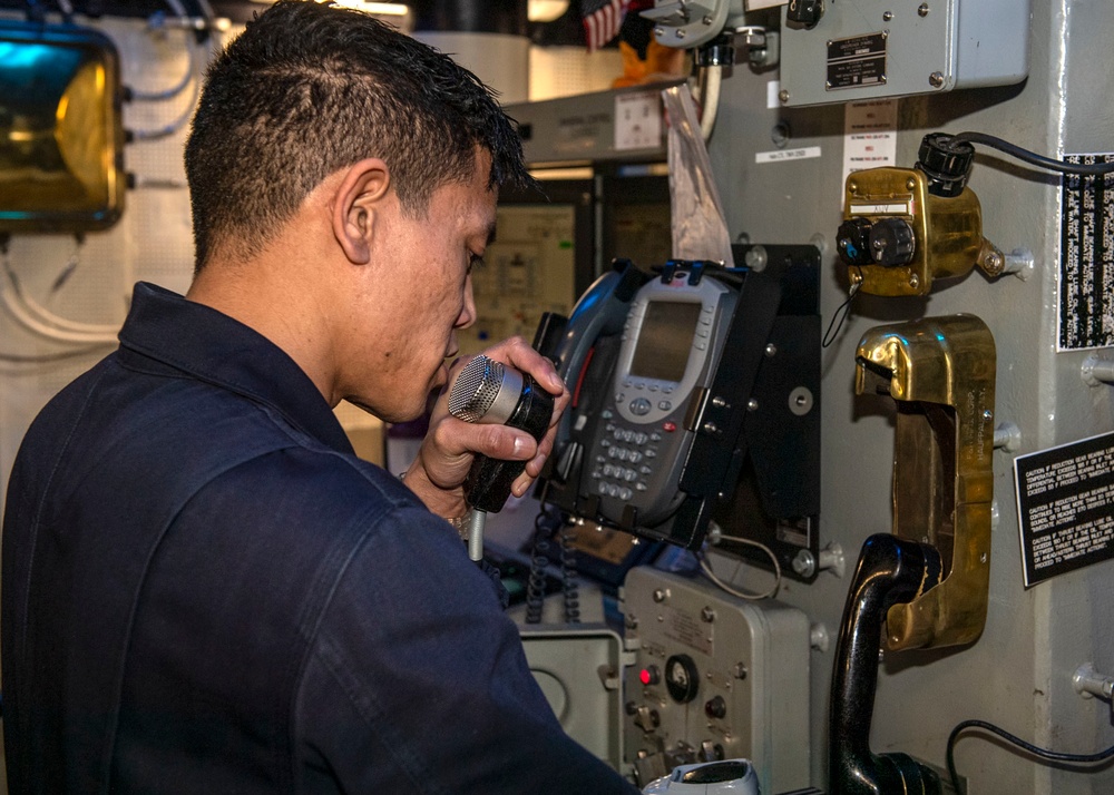 Lt. Charles Ambat, from Riverside, Calif., communicates over the 1-MC