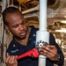 Machinist Mate 3rd Class Andre Haldane, from Philadelphia, Pa., tightens a valve in an engineering space