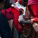 Sailors connect a y-gate to a fire hose station, during a firefighting drill