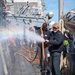 Boatswain’s Mate 3rd Class Roberto Cardenasguillen, from Fontana, Calif., sprays the hull during a fresh-water washdown