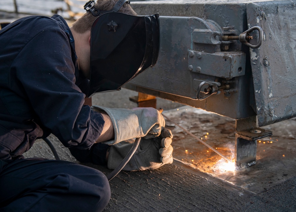 Hull Maintenance Technician 2nd Class Michael Lipe, from Lindale, Texas, welds an equipment locker to the deck