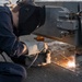 Hull Maintenance Technician 2nd Class Michael Lipe, from Lindale, Texas, welds an equipment locker to the deck