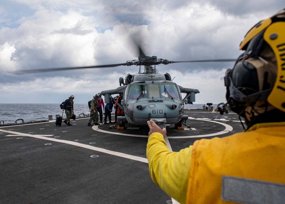 Sailors aboard Arleigh Burke-class guided-missile destroyer USS Mitscher (DDG 57) conduct a personnel transfer with an MH-60S Sea Hawk helicopter assigned to the “Dragon Slayers” of Helicopter Sea Combat Squadron (HSC) 11