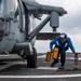 Boatswain’s Mate 3rd Class Isaiah Strickland, from Galesburg, Ill., removes chock and chains from an MH-60S Sea Hawk helicopter