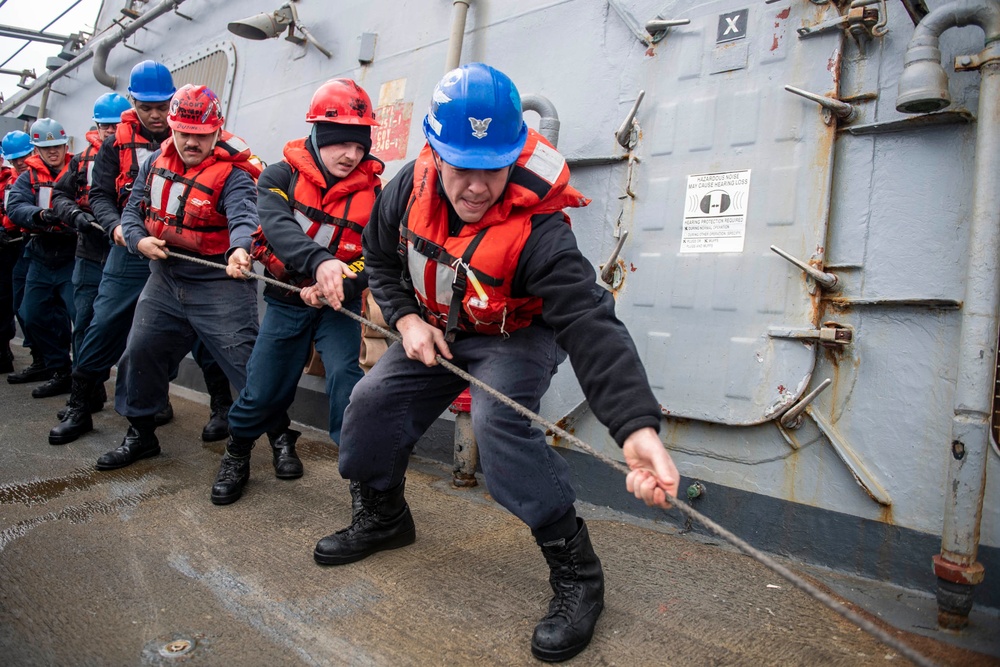 Sailors aboard Arleigh Burke-class guided-missile destroyer USS Mitscher (DDG 57) take in line during a replenishment-at-sea with Supply-class fast combat support ship USNS Supply (T-AOE-6)