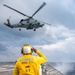 Boatswain’s Mate 3rd Class Tra’shaun Cooper, from Homestead, Texas, salutes the pilots of an MH-60R Sea Hawk helicopter assigned to the “Proud Warriors” of Helicopter Maritime Strike Squadron (HSM) 72