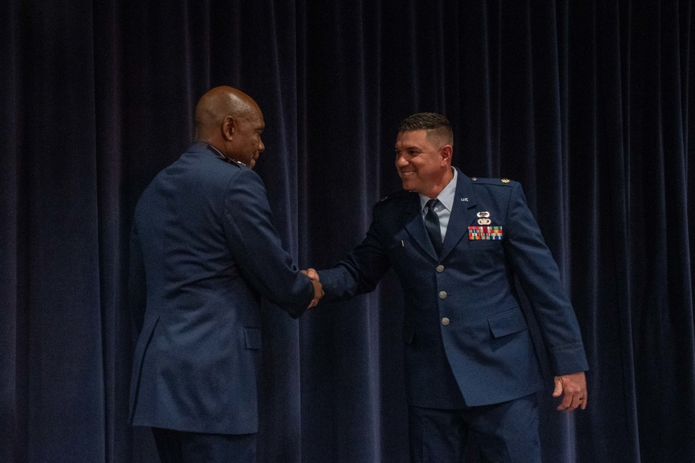 Maj. Gen. Ondra Berry shakes Maj. Robert Kolvet's hand during Kolvet's promotion ceremony