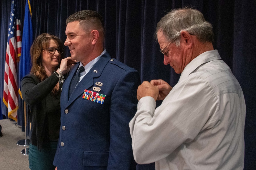 THE PINNING: Maj. Robert Kolvet's wife and father pin his new Lieutenant Colonel rank on his uniform during Kolvet's promotion ceremony