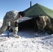Spc. Brandon Moye and Spc. Garet Sphatt remove snow to protect them against the elements