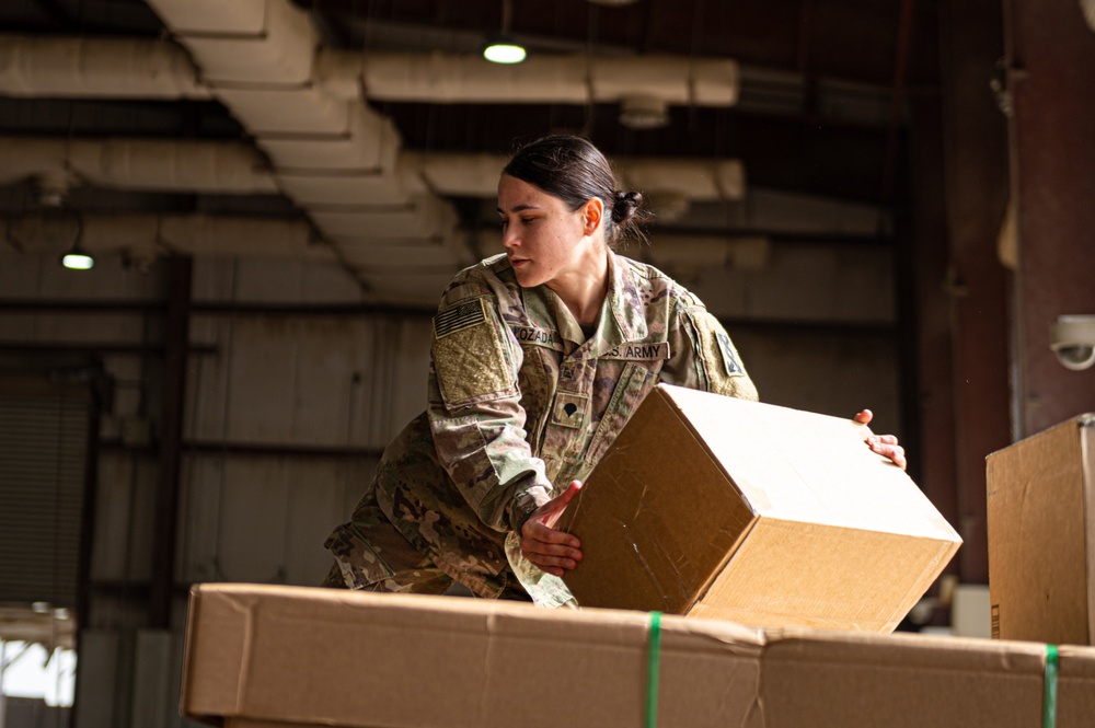Shipping a piece of home overseas: service members work together to deliver mail