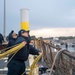 Electronics Technician 3rd Class Dennis Blanco, from Madera, Calif., throws the messenger line to the pier