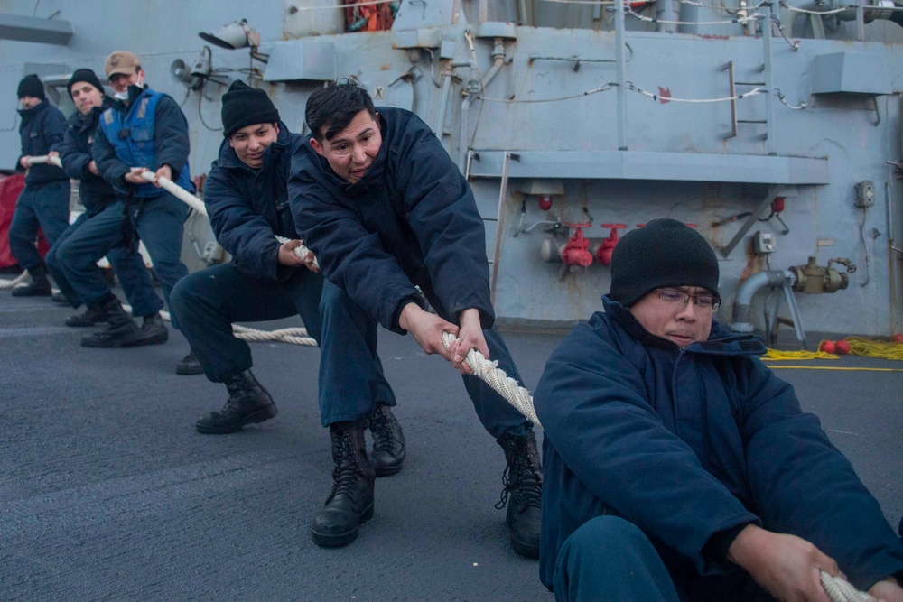 Sailors heave around on a mooring line during a sea-and-anchor detail