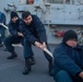 Sailors heave around on a mooring line during a sea-and-anchor detail