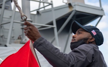 Quartermaster Seaman Lakazic Boney, from Chicago, lowers a signal flag from the starboard yardarm