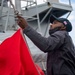 Quartermaster Seaman Lakazic Boney, from Chicago, lowers a signal flag from the starboard yardarm