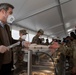 The Minister President of Bavaria, Markus Soeder, serves Weisswurst and pretzels to American Soldiers