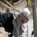 Seaman Isaiah M. Crespo, from Tampa Florida, assigned to deck department aboard the Nimitz-class aircraft carrier USS George Washington (CVN 73), closes a hatch with a dogging wrench during general quarters drill.