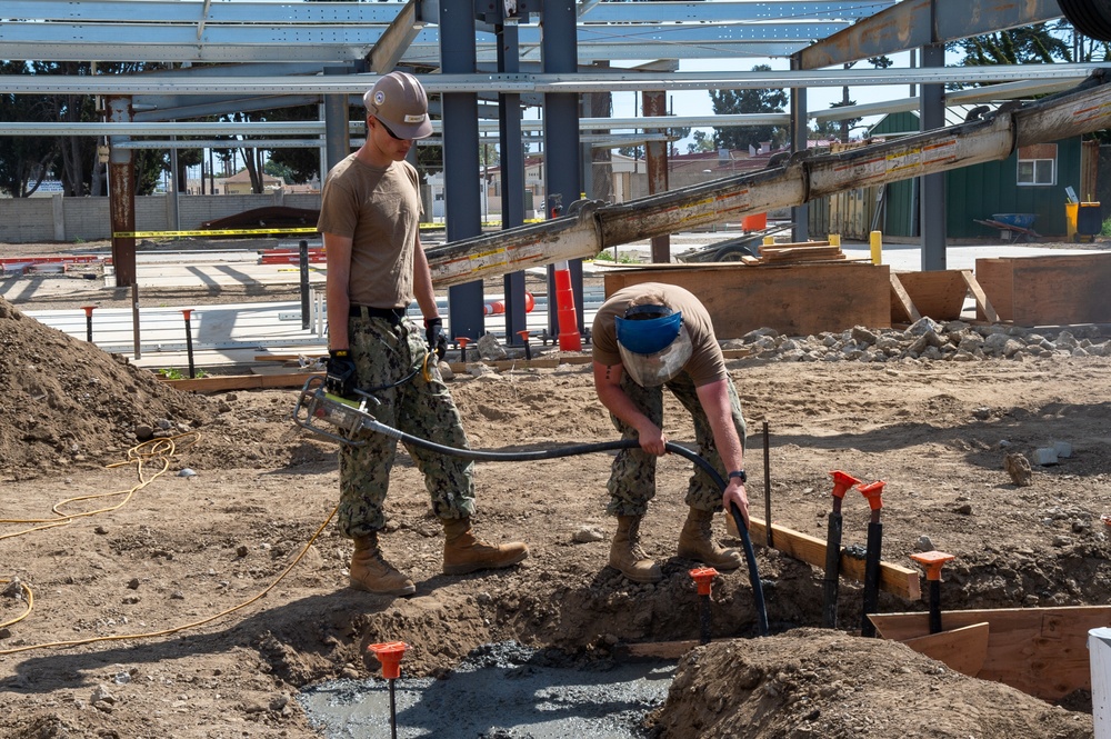 US Navy Seabees with NMCB-5 place concrete footers onboard Naval Base Ventura County