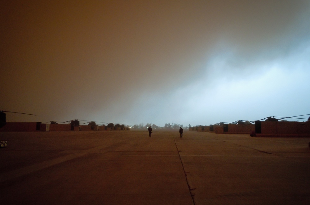 Iowa aviators walk flight line during dust storm at Camp Taji