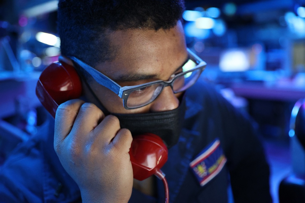 Ensign Brian Parham answers the phone as Combat Information Center Watch Officer onboard Arleigh-Burke class guided-missile destroyer USS Barry (DDG 52)