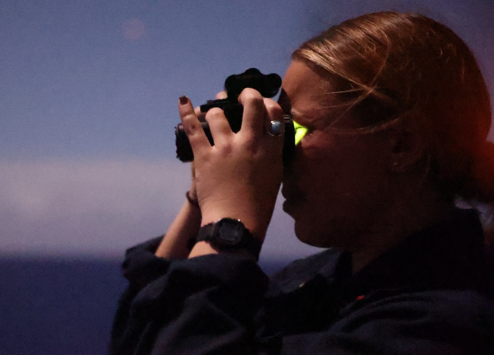 Ensign Ogent scans horizon during nighttime training on USS Barry