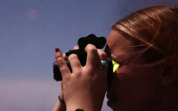 Ensign Ogent scans horizon during nighttime training on USS Barry