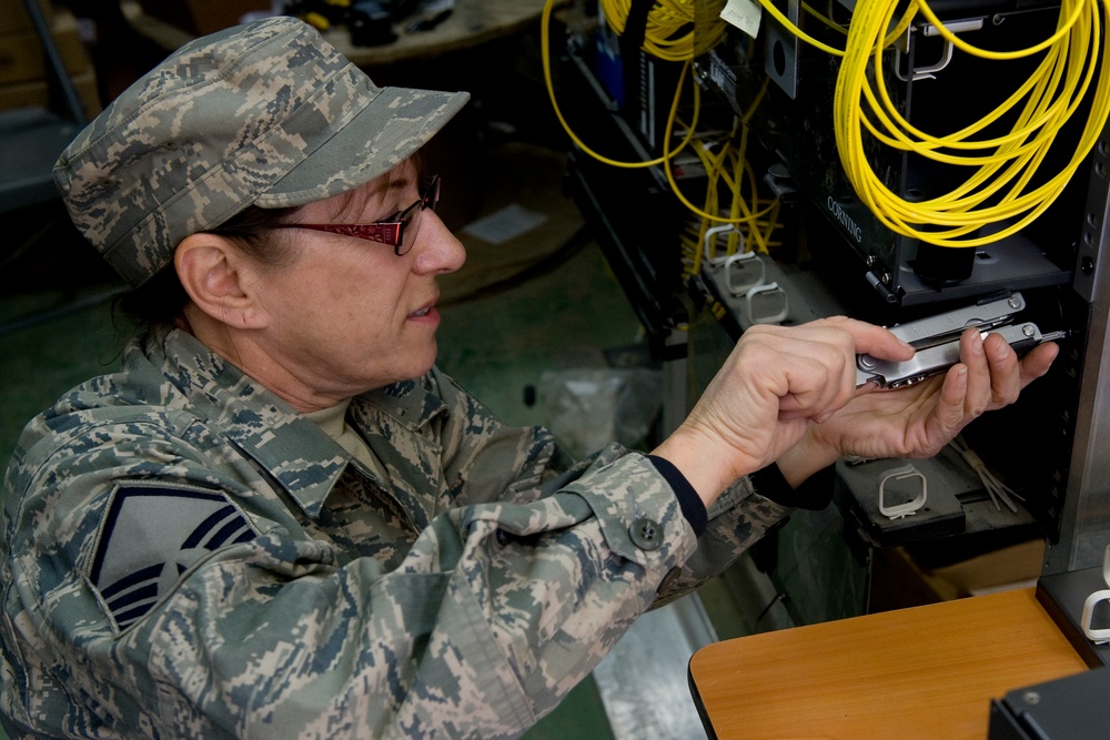 MSgt Lyn Fry prepares an equipment rack for fiber optic cable installation at Bagram Air Field in Afghanistan