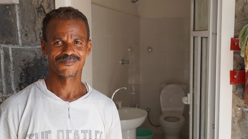 Sanitation Worker in front of Health Facility in Yemen That Received USAID Funding to Rehabilitate its Water and Sewage System