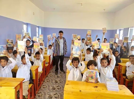 Students in Yemen Hold Up Learning Materials Developed with USAID Funding