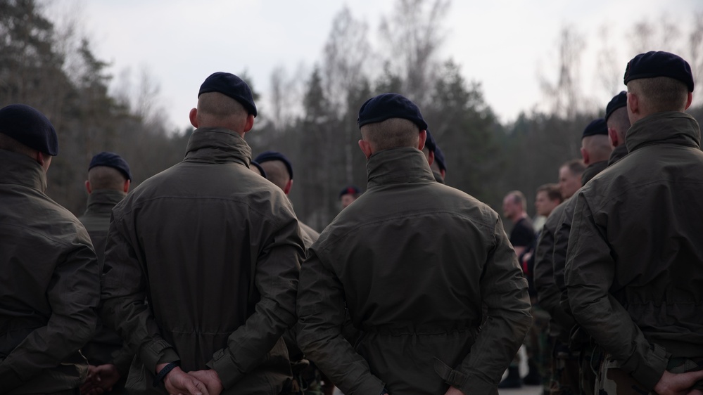 Royal Dutch Marines listen to  congratulatory remarks from their command following the successful completion of a speed march.