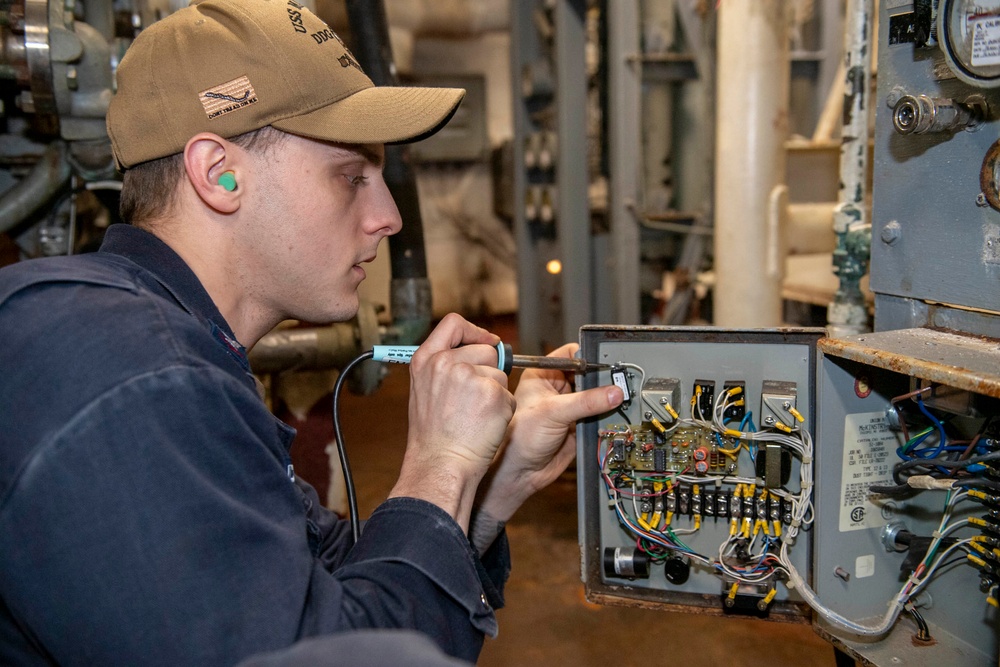 Gas Turbine Systems Technician (Electrical) 3rd Class Trevor Humphries, from Charlotte, N.C., solders a replacement switch in an engineering space