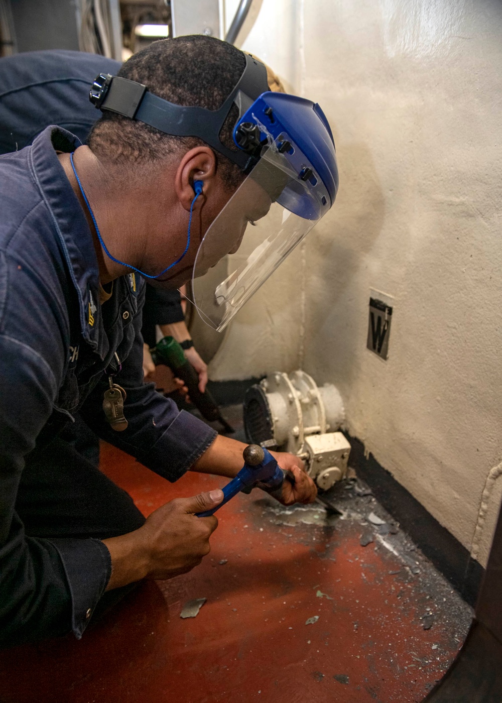 Gas Turbine Systems Technician (Mechanical) 1st Class Andrew Chin, from Mt. Vernon, N.Y., chisels the deck to adhere a non-skid mat