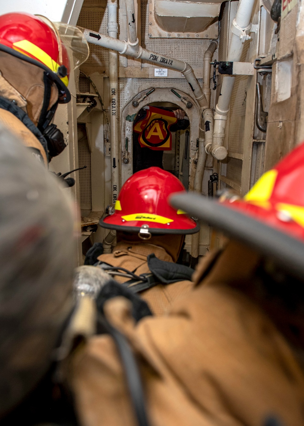 Sailors fight a simulated fire during a firefighting drill aboard Arleigh Burke-class guided-missile destroyer USS Mitscher (DDG 57)