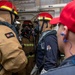 Sailors discuss firefighting procedures with a training team leader Damage Controlman 1st Class Adam Foster, right, from Norfolk, Va., during a firefighting drill