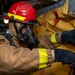 Damage Controlman Fireman Gerardo Vargasarellano, from Oklahoma City, Okla., affixes a smoke curtain to an open hatch during a firefighting drill