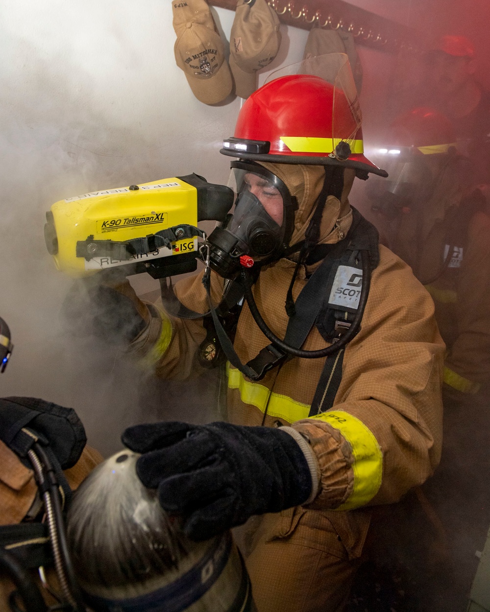 Information System Technician 3rd Class Conor Nichols, from Texarkana, Texas uses a Naval Firefighter Thermal Imager during a firefighting drill