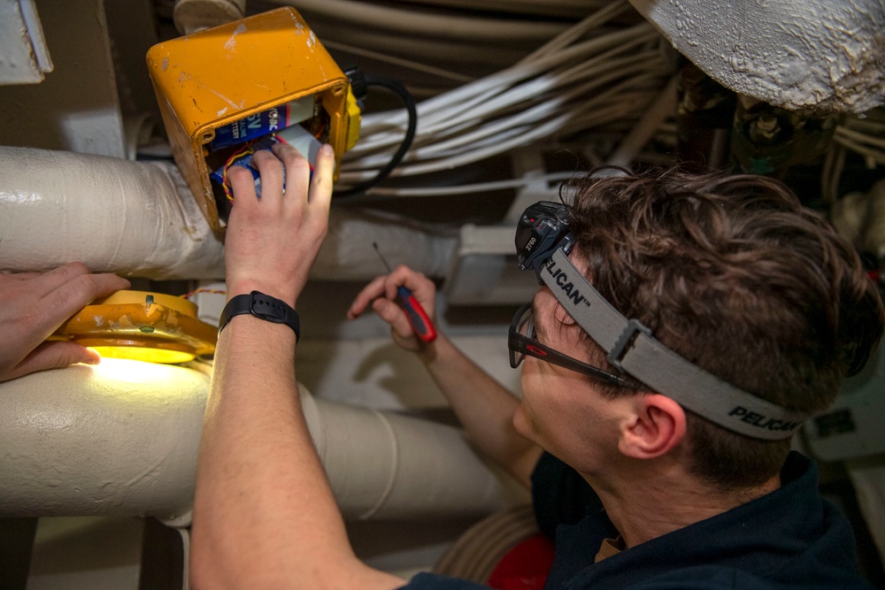 Electronics Technician 2nd Class John Flowers, from Lugoff, S.C., conducts maintenance on a battle lantern