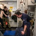 Sonar Technician (Surface) 3rd Class Daniel Bunnell, left, from Houston, Texas, and Logistics Specialist 2nd Class Alexander Knaras, right, from Salt Lake City, Utah, detain Sonar Technician (Surface) 2nd Class Samuel Williams, bottom, from Tampa, Fla.